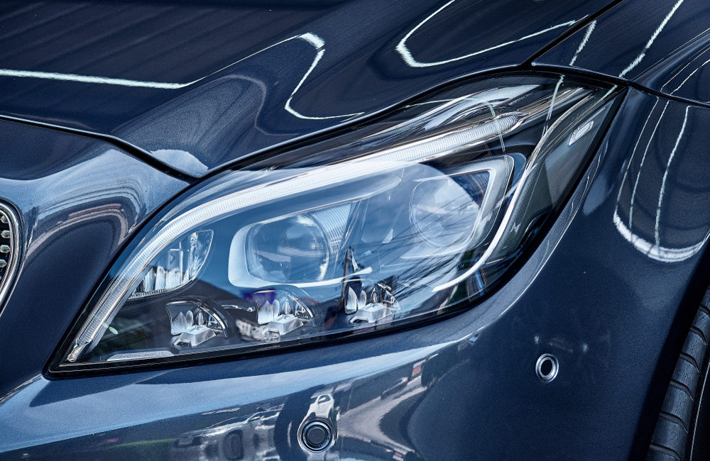 Headlight detail of blue car.
