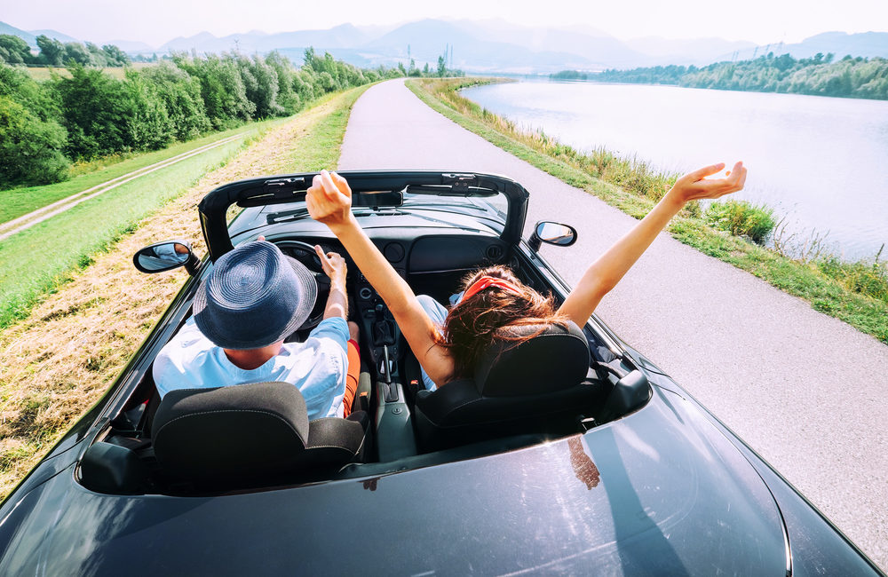 How to Ship a Car Across the Country Without Breaking the Bank - Couple in love ride in cabriolet car